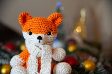 Crochet small handmade fox with a scarf in winter with Christmas decorations