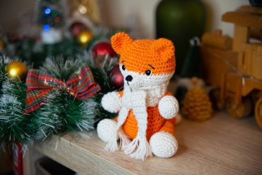 Crochet small handmade fox with a scarf in winter with Christmas decorations