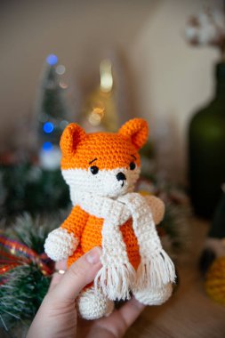 Crochet small handmade fox with a scarf in winter with Christmas decorations