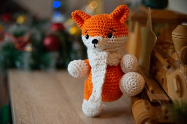 Crochet small handmade fox with a scarf in winter with Christmas decorations