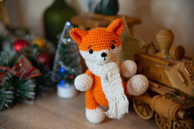 Crochet small handmade fox with a scarf in winter with Christmas decorations