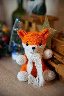 Crochet small handmade fox with a scarf in winter with Christmas decorations