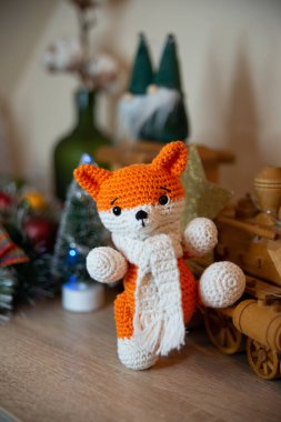 Crochet small handmade fox with a scarf in winter with Christmas decorations