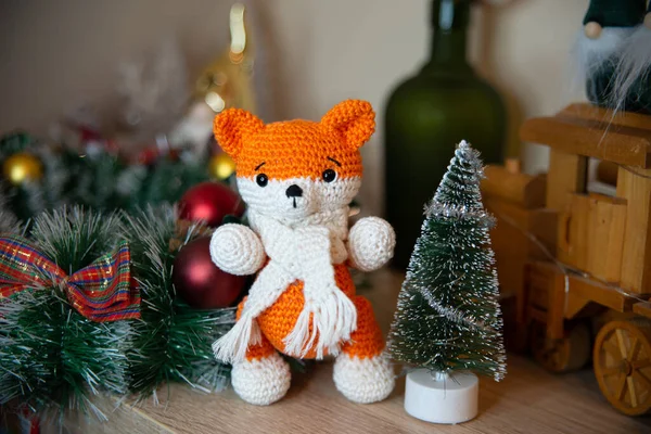 Crochet small handmade fox with a scarf in winter with Christmas decorations