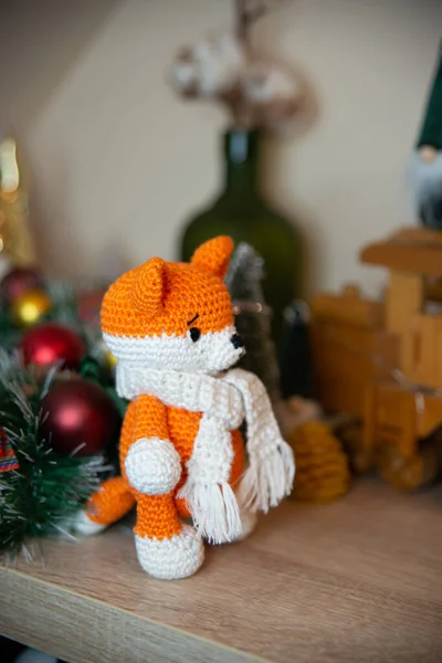 Crochet small handmade fox with a scarf in winter with Christmas decorations