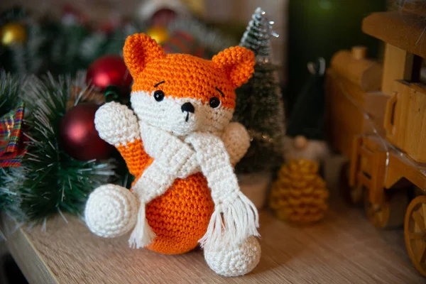 Crochet small handmade fox with a scarf in winter with Christmas decorations