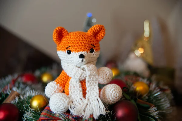 Crochet small handmade fox with a scarf in winter with Christmas decorations