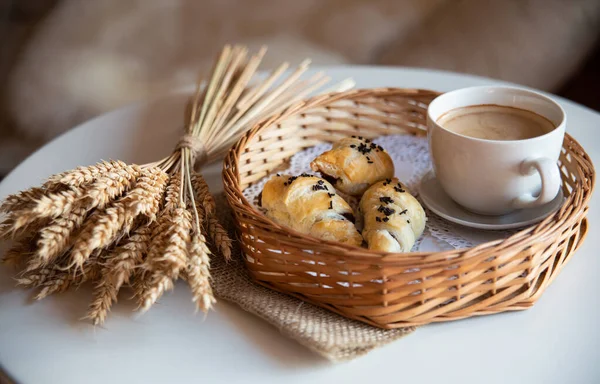 阳光明媚的早晨吃早餐 咖啡和羊角面包放在咖啡厅内的白桌上 用植物和小麦装饰 — 图库照片