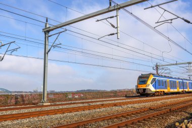 Hollanda 'da SLT sprinter treniyle Hatem ve Zwolle arasındaki IJssel nehri üzerinde Hanzeboog adlı kırmızı çelik köprü.