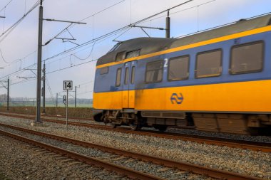 Hollanda 'da ICM Koploper treni ile Hatem ve Zwolle arasındaki IJssel nehri üzerindeki Hanzeboog adlı kırmızı çelik köprü.