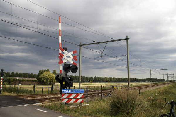 Barriers and red lights at railroad crossing in Moordrecht in the Netherlands