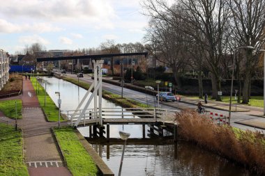 Hollanda 'daki Nieuwerkerk aan den IJssel' deki Zuidplaspolder 'ın halka kanalı üzerinde tahta asma köprü.