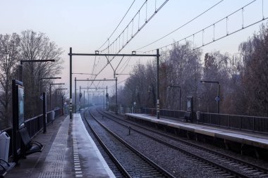 Hollanda 'daki Nieuwerkerk aan den IJssel' de platformları ve trenleri olan buzlu demiryolu rayları