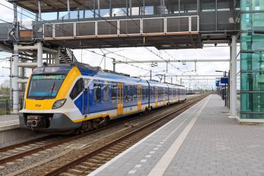 Hollanda 'daki NS için çalışan Lage Zwaluwe' da CAF tarafından yapılan SNG yerel banliyö treni raylarda ilerliyor