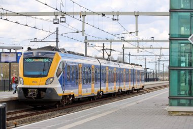 Hollanda 'daki NS için çalışan Lage Zwaluwe' da CAF tarafından yapılan SNG yerel banliyö treni raylarda ilerliyor