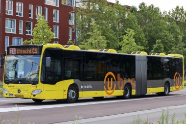 Hollanda 'nın Utrecht caddelerinde eklemli sarı U-OV otobüsü