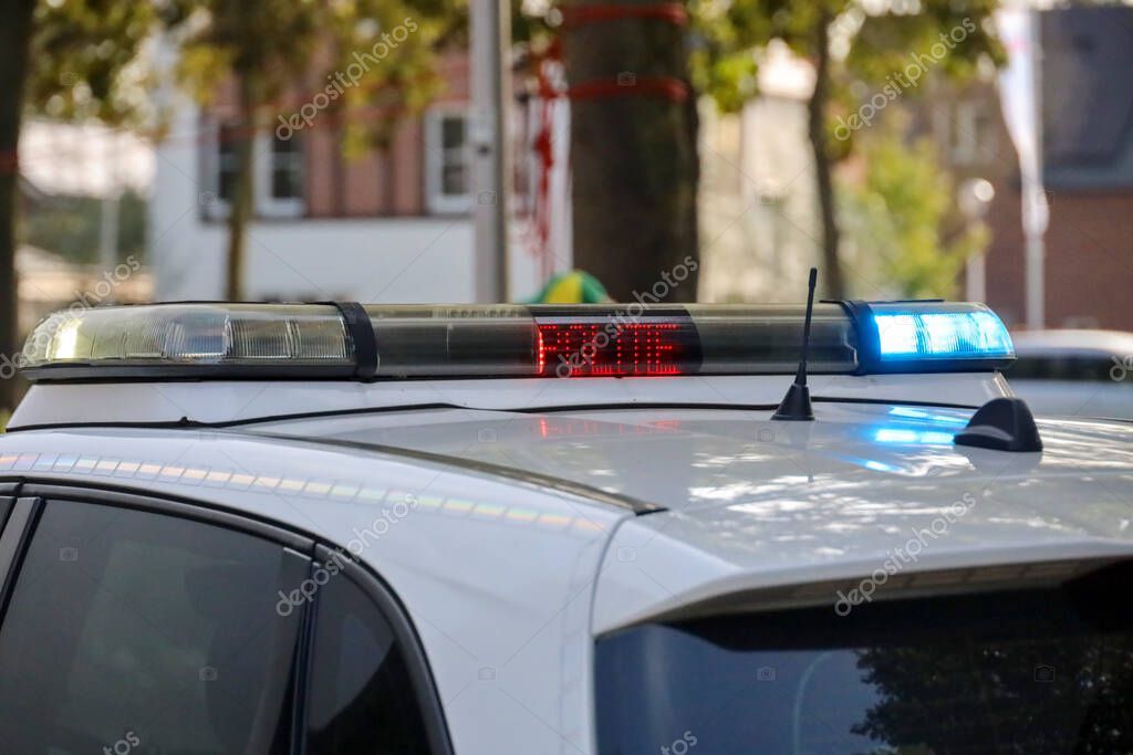 Police car in the Netherlands with blue flashlights and stop sign lit