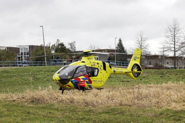Travma helikopteri doktoru, Hollanda 'daki Nieuwerkerk aan den IJssel' de geçirdiği kazadan sonra yaralı çocukla ambulans personeline yardım ediyor.