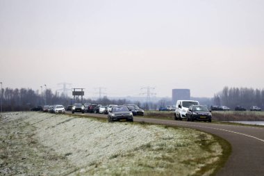 Hollanda 'daki buz patencileri için Eendrigspolder boyunca park etmiş arabalar.