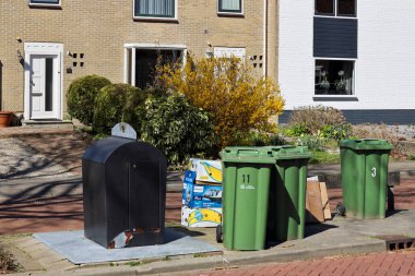 Zuidplas belediyesi tarafından toplanmaya hazır yeşil konteynırlardaki kağıt ve organik atık