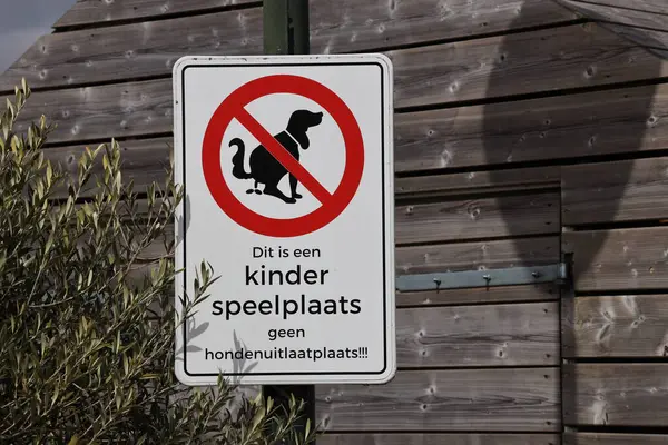 Warning on sign that children\'s playground is not a dog walking area in Dutch language in the Netherlands