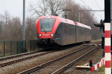 Hollanda Hardinxveld Giessendam istasyonunda kırmızı ve siyah Stadler GTW R-Net treni