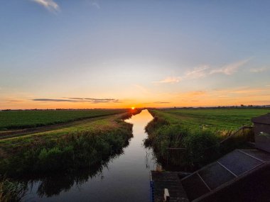 Hollanda 'daki sulama kanalında Zuidplaspold' un çayırlarında gün batımı