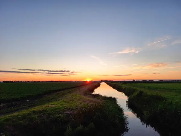 stock image Sunset over the meadows of the Zuidplaspolder at the watering canal in the Netherlands