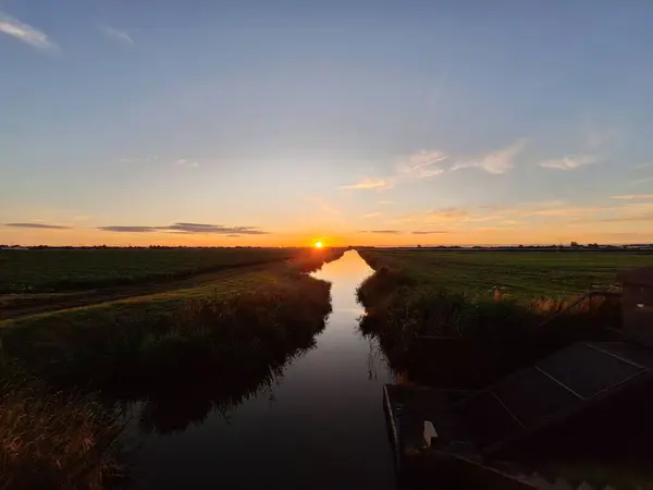 stock image Sunset over the meadows of the Zuidplaspolder at the watering canal in the Netherlands