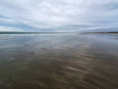 Kuzey Denizi kıyısında Hoek van Holland 'da bulutlu gökyüzü ve Hollanda kıyılarında alçak gelgitle