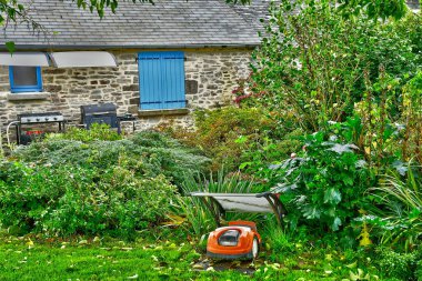 Allaire, France - october 23 2022 : a robot wich is cutting the lawn in the old village clipart