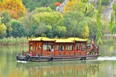 Luoyang; China - november 6 2024 : boat on river in the Longmen Grottoes site clipart