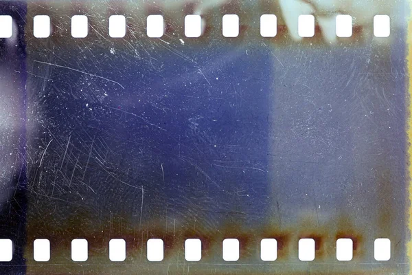 Dusty and grungy 35mm film texture or surface. Perforated scratched camera film isolated on white background.