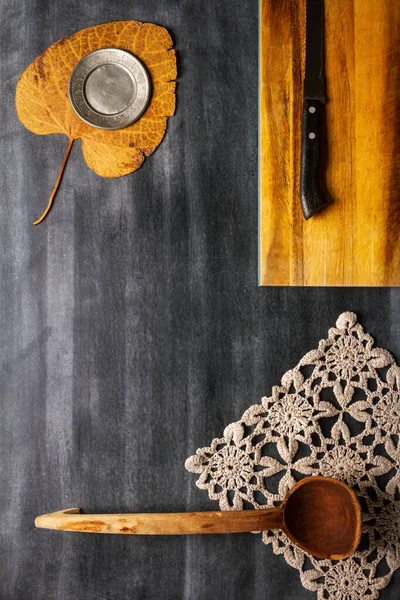 stock image Old cutting board with linen napkin and spoon on black wooden background. Flat lay. Top view. Copy space.