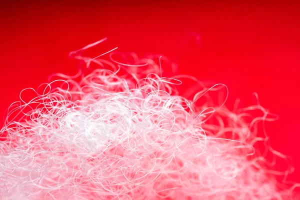 stock image Extreme macro of polyester stable fiber on red background. Selective focus, shallow depth of field. Abstract dreamy background