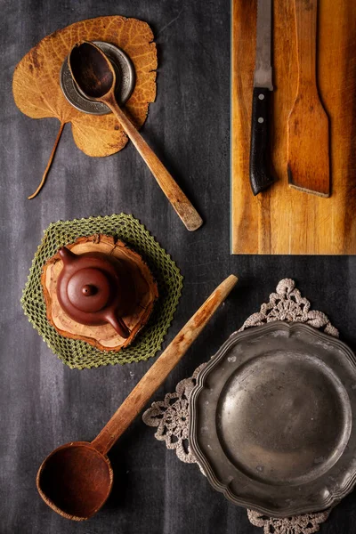 stock image Old cutting board with linen napkin and spoon on black wooden background. Flat lay. Top view. Copy space.