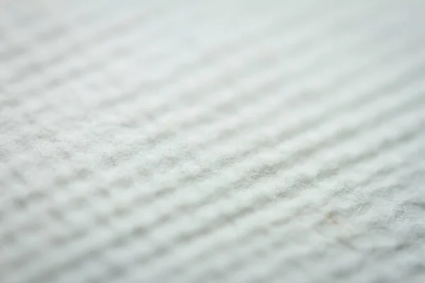 Extreme closeup of white handmade paper with dried plants. Shallow depth of field.