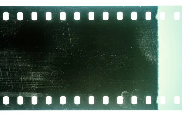 stock image Dusty and grungy 35mm film texture or surface. Perforated scratched camera film isolated on white background.