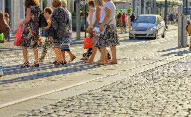 Porto 'nun şehir merkezinde birçok insan yürüyor. Portekiz 'in Porto kentindeki yaya geçidinde kalabalık caddeden geçen yayalar.