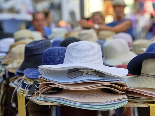 stock image Women's hats to shelter from the sun on the beach, by the sea. Many hats sold on market stalls in a seaside resort.