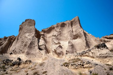Volkanik kayalıkların patlaması Vourvoulos, Santorini adası, Yunanistan 'ın kuzeydoğu kıyıları boyunca garip şekiller yaratıyor..