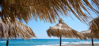 Paralia Karterados, sazdan şemsiyeli vahşi volkanik kum plajı. Yunan adaları, Santorini, Avrupa tatilleri.