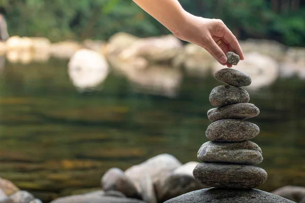 Vrouw Haar Hand Balanceert Stenen Waterval Zen Balans Meditatie — Stockfoto