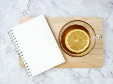 Lemon tea and book on marble texture background.