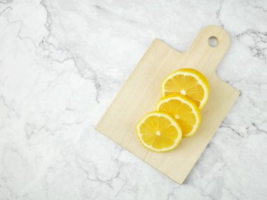 Dilimlenmiş limon tahtanın üzerinde yatıyor..