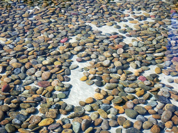 Colorful stones under water, with water effect over them.