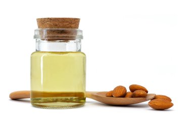 Almond oil in glass bottle and group of almond nuts isolated on white background. Almond oil with almond seeds.