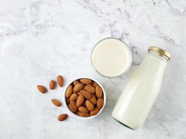 Almonds with milk on marble texture background.