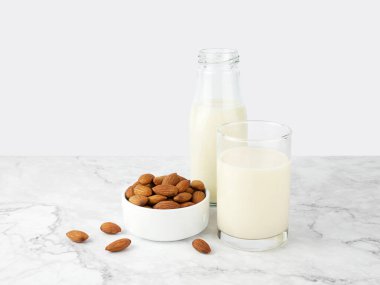 Almonds with milk on marble texture background.