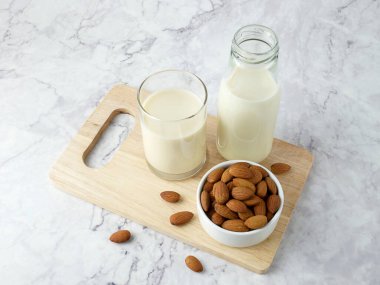 Almonds with milk on marble texture background.